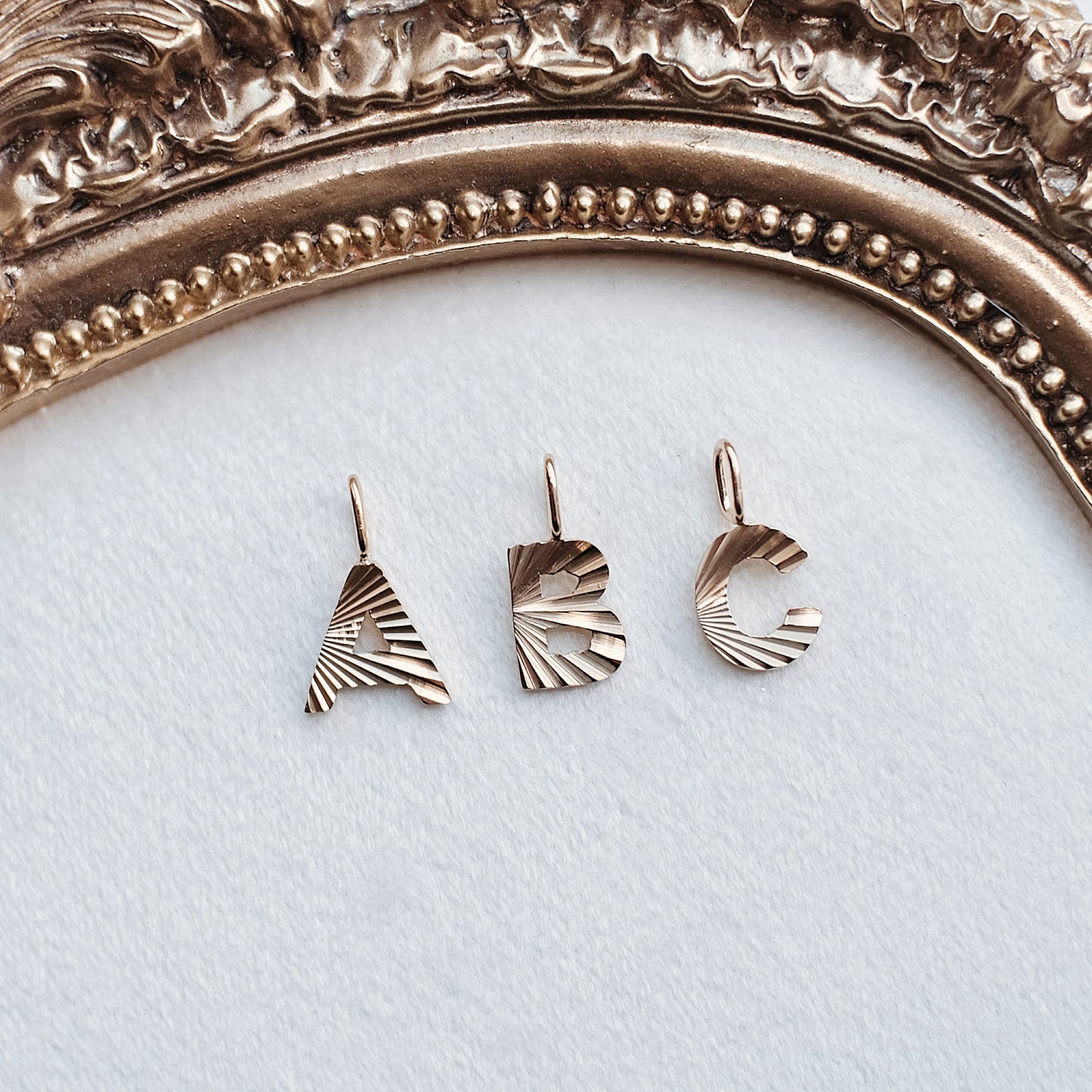 Gold Beaming Letter Charm